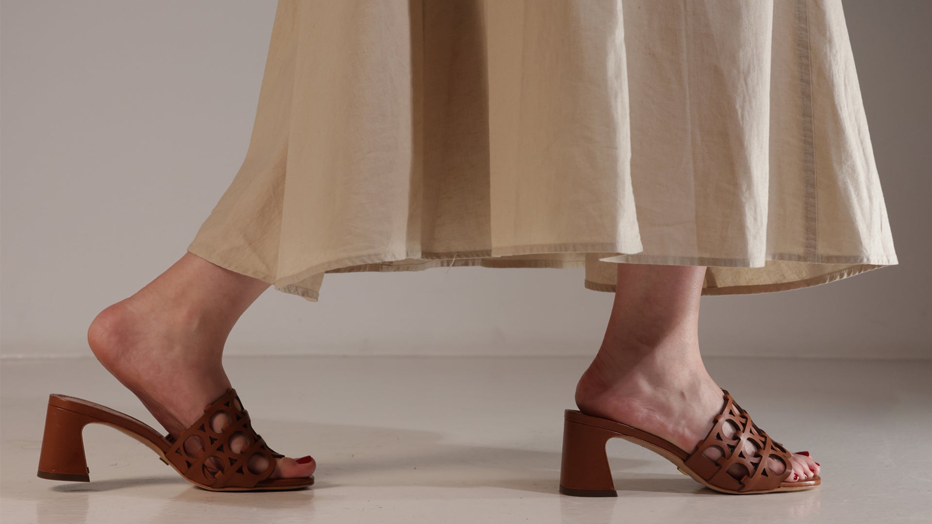 Woman walking in Elveo brown leather mules